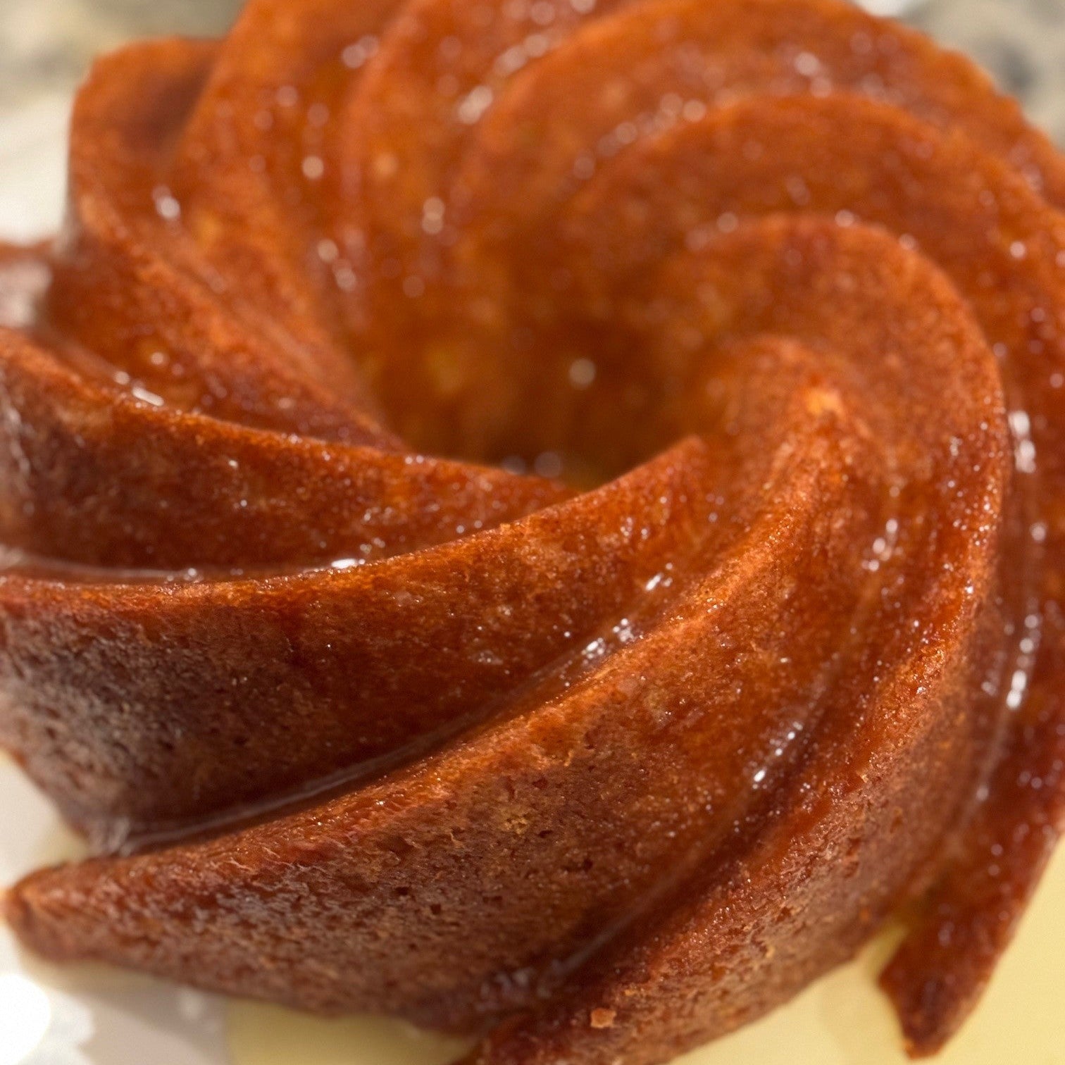 Bundt cake with a glossy finish on a reflective surface